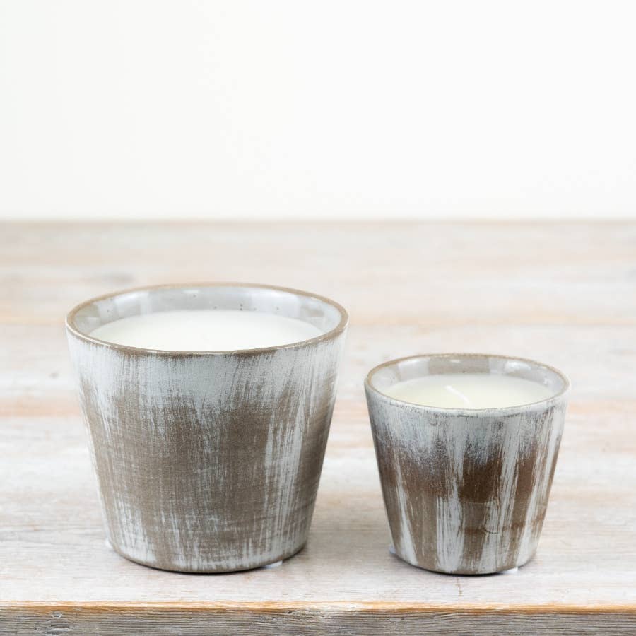Two ceramic pots with a textured finish on a wooden surface.