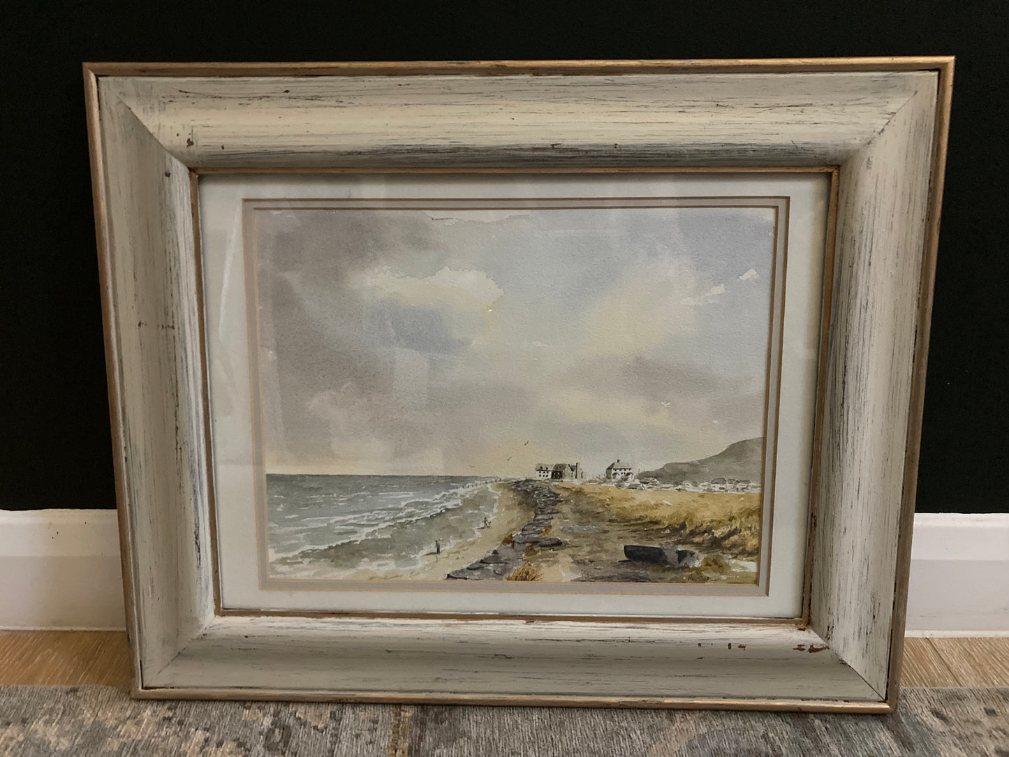 Distressed framed watercolour painting of a coastal scene.